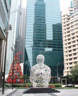 Un bouddha de verre face aux buildings de Singapour.
